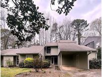 Charming single-story home with a covered carport, mature trees, and neat landscaping at 165 Woodhaven Way, Alpharetta, GA 30009