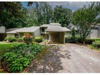 Charming home exterior with mature landscaping, a covered carport, and a welcoming entrance at 165 Woodhaven Way, Alpharetta, GA 30009