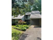 Charming home featuring a well-manicured lawn, flowering bushes, and a convenient covered carport at 165 Woodhaven Way, Alpharetta, GA 30009