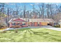 Charming brick home with a well-manicured lawn and a covered carport at 6828 Lockridge Dr, Atlanta, GA 30360