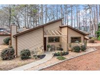 Charming home with wood siding, stone accents and professional landscaping with a winding walkway to the covered front entrance at 812 Bonnie Glen Se Dr, Marietta, GA 30067
