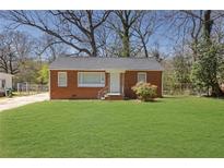 Charming brick home features a well-maintained lawn and classic architectural details at 1883 Clarke Ln, Decatur, GA 30035