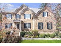 Charming brick home featuring a manicured front yard with lush landscaping and a welcoming entrance at 2555 Weddington Ne Rdg, Marietta, GA 30068
