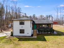 Charming two-story home with a well-maintained lawn and inviting front porch with nice stone detail at 118 Raven Rd, Villa Rica, GA 30180