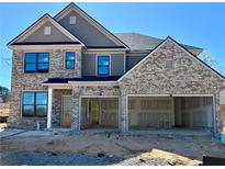 Two-story brick home featuring an attached two-car garage, and a combination of gray siding and brick at 4190 Hosch Reserve Dr, Buford, GA 30519