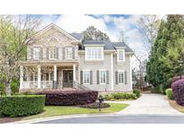 Charming two-story home with brick and shingle siding, landscaped yard, and a welcoming front porch at 570 Glengate Cv, Atlanta, GA 30328