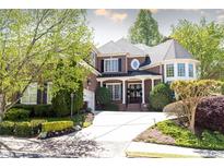 Beautiful two-story brick home featuring a manicured lawn, mature trees, and an elegant entryway with holiday wreaths at 825 Glengate Pl, Atlanta, GA 30328