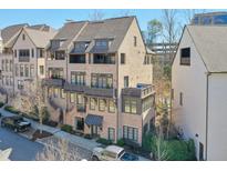 Charming brick townhome with multiple balconies and a well-maintained landscaped front yard at 6601 Cadence Blvd, Atlanta, GA 30328