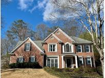 Charming two-story brick home featuring a manicured lawn and complemented by mature trees at 272 Lynshire Sw Ct, Marietta, GA 30064