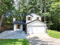 Charming two-story home features a classic design and a two-car garage at 5075 Forest Downs Ln, Atlanta, GA 30349
