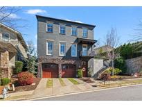 Stunning three-story home featuring a two-car garage and beautiful landscaping at 6845 Wesley Hughes Rd, Cumming, GA 30040