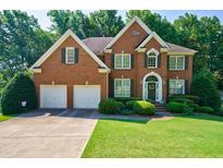 Charming two-story brick home with a well-manicured lawn and beautiful landscaping at 1192 Lake Washington Dr, Lawrenceville, GA 30043