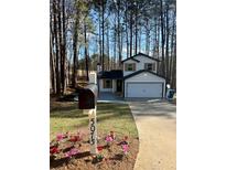 Charming two-story home with black and white accents, nestled in a wooded lot at 5075 Forest Downs, Atlanta, GA 30349