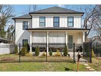 Charming two-story home featuring a well-manicured lawn and black metal fencing at 969 Parsons Sw St, Atlanta, GA 30314