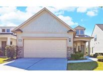Charming home featuring a two-car garage, stone accents, manicured lawn, and inviting front porch at 5638 Maple Bluff Way, Hoschton, GA 30548