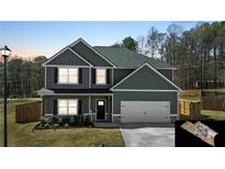 Charming two-story home with gray siding, a two-car garage, and a well-manicured lawn at 261 Webster Lake Dr, Temple, GA 30179