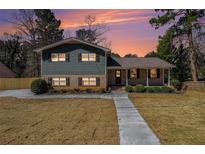 Charming two-story home featuring a brick and siding facade, a covered front porch, and a landscaped yard at 3515 Moonlight Forest Ct, Decatur, GA 30034