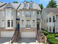 Charming three-story townhome with brick accents, private balconies and attached two car garage at 1020 Constitution Way, Cumming, GA 30040