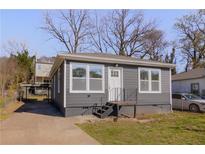 Charming home featuring a white door, gray siding, and well-maintained landscaping at 1138 Moton Sw Ave, Atlanta, GA 30315