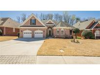 Charming one-story brick home featuring a two-car garage and well-manicured front lawn at 1913 Shenley Park Ln, Duluth, GA 30097