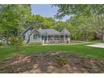 Charming single-Gathering home with inviting front porch and lush green lawn surrounded by mature trees at 2000 Mcconnell Rd, Grayson, GA 30017