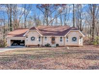 Charming single-story home with a welcoming front yard and attached garage on a sunny day at 9224 Snipe Ln, Jonesboro, GA 30236