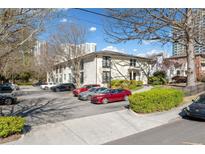 Apartment building exterior with a parking lot and trees in front of the building at 48 Peachtree Ne Ave # 412, Atlanta, GA 30305