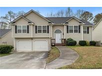 Charming split-level home with manicured lawn, two-car garage, and inviting front porch at 174 Whetstone Way, Villa Rica, GA 30180