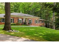 Charming brick home with a well-manicured lawn and mature trees offering great curb appeal at 4183 Paran Pines Nw Dr, Atlanta, GA 30327
