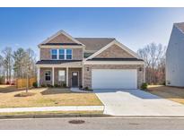 Charming two-story home with brick facade, two-car garage, and well-manicured lawn on a sunny day at 1436 Maston Rd, Auburn, GA 30011