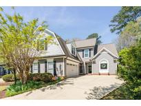 Charming two-story home with gray siding, manicured lawn, and attached two-car garage on a sunny day at 356 Ivy Glen Cir, Avondale Estates, GA 30002