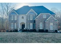 Elegant two-story home featuring a brick facade, well-manicured landscaping, and a welcoming entrance at 209 Kingscastle Dr, Ellenwood, GA 30294