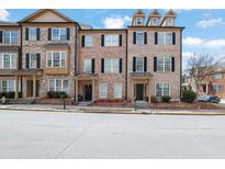 Charming brick townhome featuring black shutters and well-maintained landscaping at 1952 Appaloosa Mill Cir, Buford, GA 30519