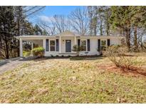 Charming renovated ranch home with white painted brick, dark shutters, and new landscaping at 5225 Maple Valley Sw Rd, Mableton, GA 30126