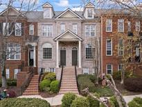 Charming townhome featuring brick facade, arched windows, well-maintained landscaping, and inviting double door entrance at 1123 Providence Pl, Decatur, GA 30033