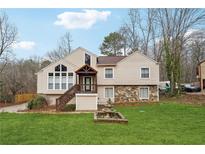 Charming two-story home featuring stone accents, a cozy porch, and a well-manicured front lawn at 3748 Woodrose Ct, Snellville, GA 30039