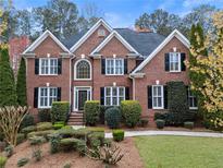 Charming two-story brick home with manicured landscaping, black shutters, and a well-maintained front yard at 1030 Chasewood Trl, Alpharetta, GA 30005
