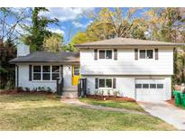 Charming split-level home featuring a bright yellow front door and a well-manicured lawn at 3632 Glen Mora Drive, Decatur, GA 30032