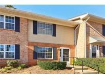 Two story townhouse with brick and beige vinyl siding and dark shutters on a sunny day at 386 Northdale Ct, Lawrenceville, GA 30046