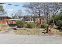 Charming brick home featuring a covered carport and sunroom, set back from the street at 340 Brooks Sw Ave, Atlanta, GA 30310