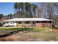 Charming single-story home with a brick facade, covered porch, and well-maintained front yard at 3701 Rainbow Cir, Snellville, GA 30039