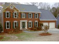 Charming two-story brick home with a well-manicured lawn, dark green shutters, and a two-car garage at 179 Hunters Crk, Dallas, GA 30157