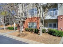Charming condo with brick and siding, featuring a private balcony and manicured landscaping at 6020 Woodland Ln, Alpharetta, GA 30009