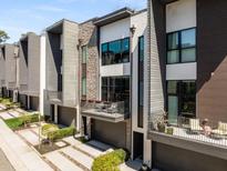 Modern townhome with mixed materials, a balcony, and a gray garage door and walkway at 103 Birch St, Decatur, GA 30030