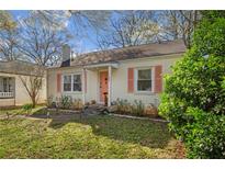 Charming single-story home with a well-manicured lawn, cute shrubs, and a coral-colored front door at 1277 Mcpherson Se Ave, Atlanta, GA 30316
