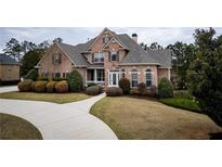 Beautiful two-story brick home featuring a well-manicured lawn and elegant landscaping at 912 Fire Thorn Dr, Hampton, GA 30228