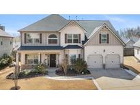 Charming two-story home featuring a well-manicured lawn and an inviting front porch at 1645 Renfroe Run, Cumming, GA 30041