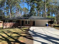 Beautiful brick home featuring a long driveway and a spacious carport at 4430 Locksley Rd, Tucker, GA 30084