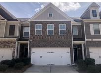 Inviting two-story townhome featuring a brick facade and a two-car garage at 849 Arbor Crowne Dr, Lawrenceville, GA 30045
