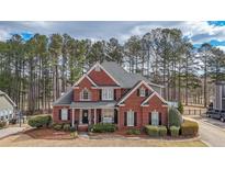 Charming two-story brick home with a well-manicured lawn and mature trees providing a private, serene setting at 151 Creek Bank Dr, Acworth, GA 30101